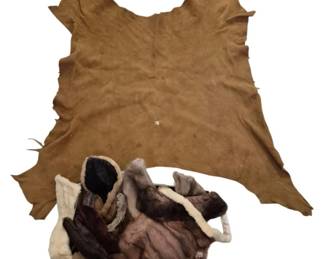 3930 - Tanned Leather Pelt & Assorted Fur Collars (Description): A tanned leather pelt in a warm brown tone,  accompanied by a collection of assorted fur  collars in various colors including brown,  cream, and gray. The pelt displays the  natural irregular edges characteristic of a complete hide. The fur collars appear to be  vintage pieces suitable for garment  embellishment or crafting projects.