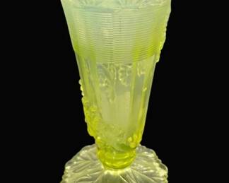 2770 - Northwood Vaseline EAPG Uranium Glass Vase (Description): A 6-inch Vaseline glass vase made with  uranium by Northwood, which gives it its  characteristic yellow-green color and causes  it to glow under ultraviolet light. The vase  is Northwood's Fluted Scroll and Vine With Flower Band pattern produced around1899.