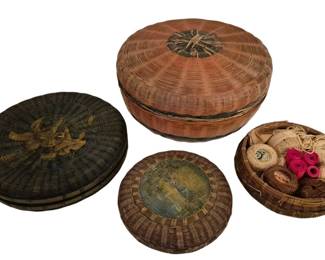 4055 - Three Vintage Woven Sewing Baskets w/ Lids (Description): Collection of three sewing baskets featuring  woven construction with fitted lids. The  baskets vary in size and color, including a  red-toned basket, a dark green basket with  decorative woven medallion on the lid, and a smaller natural-toned basket. One basket  contains assorted sewing notions including  spools of thread and twine. Each basket  features traditional coiled weaving technique  with decorative knotted finials on the lids.