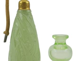 861 - 2 Vintage Green Perfume Bottles 6.5" (Description): Two vintage perfume bottles in green glass.  The taller bottle measures 6.5 inches and  features a frosted green satin glass body  with molded leaf and berry design, fitted  with a brass atomizer mechanism and cord. The smaller bottle is a clear green glass with a  footed base.