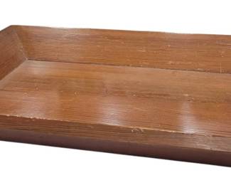 678 - Wood Serving Tray 3"x23"x16" (Description): Wooden serving tray featuring a rectangular  shape with cut-out handles on each end for  easy carrying. The tray has a warm, natural  wood finish with visible grain. Measures 3  inches tall by 23 inches long by 16 inches wide.