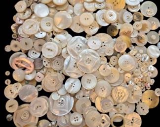 1462 - Assorted Vintage Mother of Pearl Buttons (Description): A collection of assorted vintage mother of  pearl buttons in various sizes, shapes, and  styles. The lot includes a wide variety of  designs ranging from simple two-hole and  four-hole buttons to carved and decorative examples. Buttons feature different finishes  and patinas consistent with age, with colors  ranging from creamy white to golden tan  tones. An excellent assortment for  collectors, crafters, or seamstresses.