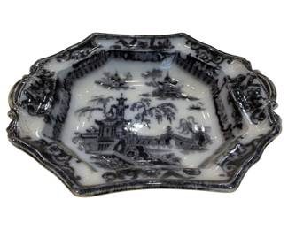 662 - Flow Blue Chinoiserie Bowl 2"x11"x9" (Description): A flow blue chinoiserie bowl featuring a  pagoda and landscape scene. The bowl has a  scalloped edge with decorative handles.  Measures 2 inches high by 11 inches wide by 9  inches deep.
