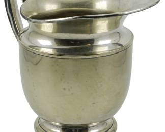 79 - Sheffield Silver Co. Silver Plate Pitcher 7.5" (Description): Sheffield Silver Co. silver plate pitcher  featuring a classic form with angular handle  and generous pour spout, raised on a circular  stepped foot. Measures 7.5 inches in height.