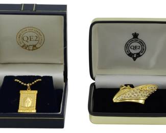 1947 - 2 Gold Tone Cunard QE2 Pieces of Jewelry (Description): Two gold tone Cunard QE2 pieces of jewelry.  This lot includes two commemorative jewelry  items from the Cunard Steam Ship Company's  Queen Elizabeth 2 ocean liner, both presented  in original branded presentation boxes.