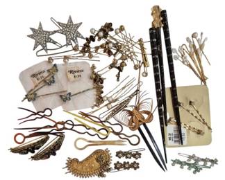 1988 - Group Vtg Hair Accessories (Description): Group of vintage hair accessories including  decorative hair pins, bobby pins, hair  sticks, and barrettes in various styles. The  collection features rhinestone star-shaped  pins, butterfly bobby pins by Riviera, ornate gold-toned hair combs, crystal-tipped hair  picks, enameled lacquer hair sticks, and  assorted decorative bobby pins with floral  and cross motifs. Materials include gold and  silver-toned metals, rhinestones, pearls, and