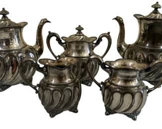 1675 - 5 Pc Silver Plate Tea Set (Description): The set includes a teapot, coffee pot, sugar  bowl with lid, creamer, and waste bowl, all  featuring matching decorative design with  ornate footed bases.