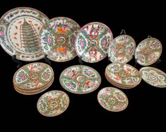 501 - 17 Chinese Rose Medallion Plates & Saucers (Description): A collection of 17 Chinese Rose Medallion  plates and saucers. The assortment includes  various sizes featuring traditional  hand-painted enamel decoration with figural  court scenes, floral panels, birds, and butterflies in characteristic green, pink,  and gold palette. The collection includes one  large oval platter with a pagoda motif,  several dinner plates, smaller plates, and  saucers, all displaying the classic Rose