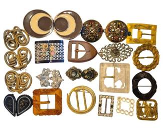 1469 - Group Vintage Buckles Various Materials (Description): A collection of vintage buckles in various  materials and styles. The group includes  examples in amber Bakelite, gold-tone metal,  silver-tone filigree, enamel with floral  motifs, mother of pearl, carved wood, rhinestone-accented pieces, and ornate  Victorian-style designs. Styles range from  Art Deco geometric shapes to elaborate  scrollwork patterns. An excellent assortment  for collectors or fashion restoration