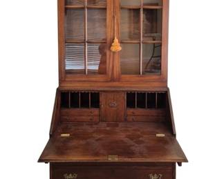 313 - Mahogany Secretary w/ Bookcase by Howerton (Description): A handsome mahogany secretary desk with  bookcase top in Georgian style. The upper  section features a glazed bookcase with two  glass-paned doors beneath a dentil molded  cornice. The lower section consists of a slant-front desk with fitted interior, re