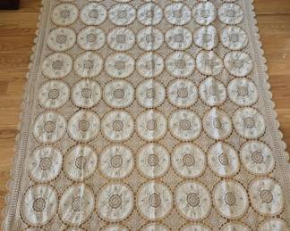 1311 - Vtg Ecru Lace Tablecloth 74"x59" (Description): Vintage ecru lace tablecloth featuring an  intricate pattern of circular medallions with  crocheted borders. The piece displays  delicate needlework with floral and geometric  motifs throughout, finished with a scalloped crochet edge. Measures 71 inches by 100  inches.