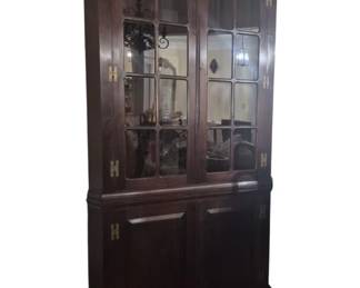316 - Mahogany Corner Cabinet 81"x40"x20" (Description): A handsome mahogany corner cabinet featuring  a molded cornice above three glass-paned  doors with brass H-hinges. The upper display  section has divided glass panels allowing  visibility of shelving within. The lower section contains two solid wo