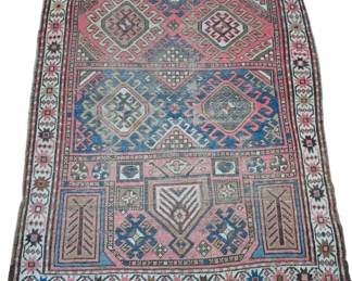 1272 - Antique Caucasian Prayer Rug 56"x43" (Description): Antique Caucasian prayer rug featuring  traditional geometric medallion designs in  shades of pink, blue, cream, and tan. The rug  displays a classic prayer niche motif with  diamond-shaped medallions in the upper field and architectural mihrab elements in the  lower section. Bordered with a decorative  ivory band featuring repeating geometric and  floral motifs. Shows age-appropriate wear  consistent with its vintage. Hand-knotted
