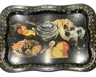 1212 - Vtg Coca-Cola Metal Serving Tray 19"x13.5" (Description): Vintage Coca-Cola metal serving tray  featuring a decorative still life scene with  food, fruits, cheese, bottles, and a silver  tureen. The black tray has a scalloped edge  with a hand-painted gold vine and leaf border.