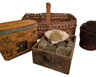 4174 - Group Lot of Vtg Collectibles (Description): Group lot of collectibles including a vintage  advertising woven basket with wooden lid  featuring a general store motif, a woven  splint basket with handle, a wooden crate  filled with assorted glass flower frogs, and a stacked wooden puzzle block.