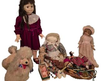3728 - Vtg Dorothy Doll w/ Accessories & Friends (Description): A charming collection of vintage dolls and  accessories centered around a Dorothy doll.  The grouping includes a tall doll in a  burgundy velvet dress with lace collar, a  faceless cloth doll in period dress, a porcelain doll in pink Victorian-style attire  with bonnet, and a plush teddy bear. The lot  also features various miniature accessories  including small figurines, a woven basket  with assorted items, beads, and other