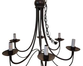 3958 - Black Metal 6-Light Chandelier 23"x24" (Description): Black metal six-light chandelier featuring  graceful curved arms with candle-style lights  and circular drip pans. The fixture has a  traditional farmhouse aesthetic with a  central ball finial and hanging chain. Measures 23 inches by 24 inches. Used as is electric/electronic/mechanical  item. No guarantee all components, untested.