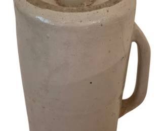 3987 - Antique Stoneware Foot Warmer with Handle (Description): Antique stoneware foot warmer featuring a  cylindrical form with an integrated loop  handle for easy carrying. The piece is  finished in a cream-colored glaze with a  smooth, glazed surface. This utilitarian item was traditionally filled with hot water and  used to warm beds or keep feet comfortable  during cold weather. Shows typical  age-related wear consistent with period use.