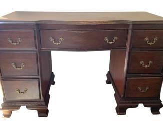 1340 - Vintage Bracket Foot Mahogany Vanity (Description): Mahogany vanity featuring multiple drawers  with decorative brass bail pulls. The piece  has a serpentine front design with canted  corners and rests on bracket feet with carved  detailing. Measures 29.5 inches tall by 49.5 inches wide by 20 inches deep.