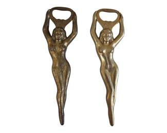 561 - Pr Brass Nude Lady Figural Bottle Openers 7" (Description): Pair of brass figural bottle openers in the  form of nude women with arms raised overhead  forming the opener portion. The Art  Deco-inspired design features elegant  feminine figures with fan-like decorative elements behind the heads. Each opener  measures 7 inches in length.