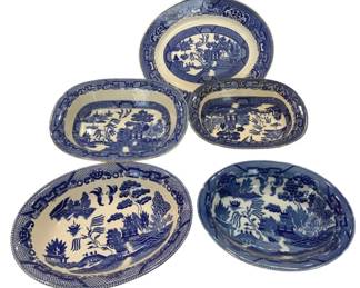 970 - Collection of Blue Willow Transferware (Description): Bowls and platters featuring the classic Blue  Willow pattern. Includes various sizes and  shapes of oval platters and bowls, each  decorated with the traditional  Chinese-inspired landscape scene depicting pagodas, bridges, willow trees, and birds.