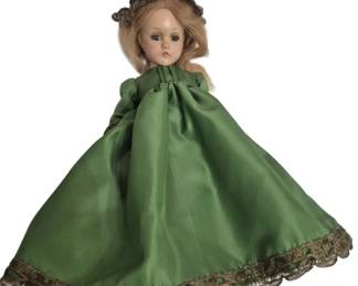 1267 - Vtg Madame Alexander Style Doll Green Gown (Description): Vintage composition doll in the style of  Madame Alexander, featuring blonde hair and  sleep eyes. The doll is dressed in an elegant  green satin gown with ornate gold lace trim  at the hem and wears a decorative gold crown or headpiece. Measures 15".
