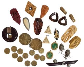 1999 - Vtg Asian, Bakelite & Carved Jewelry Lot (Description): A collection of vintage Asian, Bakelite, and  carved jewelry pieces. The lot includes an  assortment of carved pendants and dress clips  in various materials including Bakelite in  amber, butterscotch, and deep red tones. Also featured are carved bone or ivory-toned  pieces with leaf and floral motifs, wooden  carved elements, and a selection of  brass-toned Asian-style coins and medallions  with decorative motifs. Additional pieces