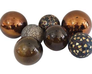 426 - 7 Glass Decorative Balls 5"x5" (Description): Collection of seven decorative balls in  various finishes and designs. The assortment  includes copper-toned metallic spheres, amber  and brown glass orbs, a crackled textured  ball, one with hand-painted floral motifs on a dark background, and a mosaic-style ball  with gold and brown tile pieces. Each ball  measures 5 inches by 5 inches.