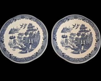 516 - 2 Johnson Bros Blue Willow Hot Plates 9" (Description): Pair of blue and white ceramic hot plates  featuring the classic Blue Willow pattern.  This traditional transferware design depicts  the iconic Chinese-inspired scene with  pagodas, willow trees, birds in flight, and a bridge.