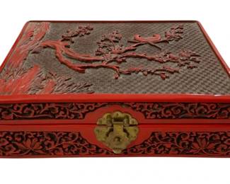 2756 - Cinnabar Carved Oriental Lacquer Jewelry Box (Description): A cinnabar carved Oriental jewelry box  featuring intricate lacquer work. This  decorative box showcases traditional carved  design elements with a brass clasp closure.  Measures 3 x 10 x 7