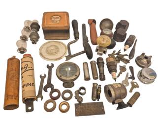 2729 - Group Vintage Automotive Items & Tools (Description): A collection of vintage automotive items  including headlight bulbs, a fuel pump repair  kit tin, a hand brace tool, wrenches,  flashlights, an automotive gauge, various  keys, gaskets, spark plugs, a Whipping tool container, an identification plate, and  assorted hardware and mechanical components.  An interesting assemblage of early to  mid-20th century automobile parts and  accessories.
