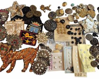 1991 - Group Vintage Buttons & Sewing Notions (Description): Group of vintage buttons and assorted sewing  notions. The collection includes an extensive  variety of buttons in various sizes and  styles, featuring metal filigree buttons,  mother of pearl buttons on original cards, black glass buttons, brass buttons, and  decorative rhinestone-set pieces. Also  included are beaded appliques in amber,  black, and gold tones, embroidered patches,  and decorative trims. Many buttons remain on