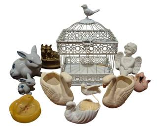 4043 - Group Lot of Animal Figurines & Accessories (Description): A charming collection of animal figurines and  decorative accessories. The lot includes a  white decorative metal birdcage with ornate  scrollwork and a bird finial on top, ceramic  swan planters in white and pink, porcelain rabbit figurines in blue and white, a brass  double cat figurine on a round base, a white  ceramic cherub or angel bust, a small ceramic  duck, and an amber-colored glass or resin  piece. A delightful assortment suitable for