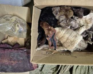 4106 - Box Lot of Fur Collars & Leather Pelts (Description): A box lot containing assorted fur collars and  leather pelts. The collection includes  various fur pieces in natural tones including  blonde, brown, black, and rust colors,  suitable for crafting, costume design, or vintage garment restoration. Also included  are leather pelts in burgundy and natural tan  shades.