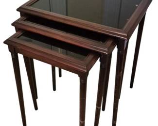 3726 - Set of 3 Mahogany Nesting Tables (Description): Set of three mahogany nesting tables with  glass inset tops. Each table features elegant  tapered legs with decorative turned details.  The graduated sizes allow the tables to nest  neatly together for convenient storage. The largest table measures 21.5" x 18" x 14".