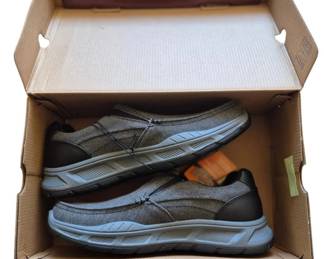 2841 - Skechers Memory Foam Sneakers Size 10.5 (Description): Skechers Memory Foam sneakers in size 10.5,  presented in original box. The slip-on style  shoes feature a gray and black colorway with  blue accent trim on the soles.