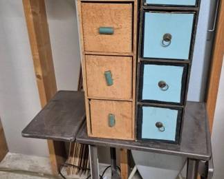 4087 - Group of Sewing Room Supplies & Storage (Description): A group of sewing room supplies including  wooden storage units with multiple drawers.  The collection features a set of light blue  painted drawers with ring pulls and natural  wood drawers with painted turquoise handles. Also included is a metal industrial-style  stool and various sewing accessories. A  practical assortment for organizing a craft  or sewing workspace. Used as is electric/electronic/mechanical