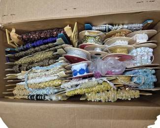 4117 - Box Lot of Vintage Sewing Ribbons and Trims (Description): Box lot of vintage sewing ribbons featuring  an extensive assortment of decorative trims.  The collection includes various styles such  as braided gimp, sequined trim, beaded  fringe, lace edging, metallic ribbon, and ornate passementerie in gold, silver, cream,  blue, brown, and jewel tones. Many pieces are  wound on original spools and cards. An  excellent resource for sewing, crafting,  upholstery, or costume making.