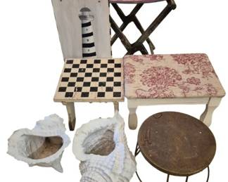 3962 - Group Lot of Decorative Furniture & Planters (Description): A group lot of decorative items including a  painted wooden chair with lighthouse motif  and checkerboard seat, a pink and red  toile-covered footstool with white painted  legs, a folding camp stool with striped fabric seat, a small round metal side table  with rustic finish, and two white  shell-shaped planters in conch and clam  designs.
