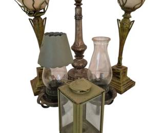 4010 - Group of Decorative Lamps and Lighting Items (Description): A group of decorative lighting items  including a pair of Art Deco style torchiere  lamps with frosted glass shades and  bronze-toned metal bases, a wooden turned  candlestick with ornate carved details, a small hurricane lamp with glass shade and  fabric covered shade, a clear glass hurricane  chimney, and a brass and glass lantern with  beveled glass panels. An eclectic collection  suitable for various decorative applications.