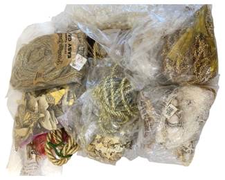 362 - Box Lot of Gold Roping Tassels Decor (Description): Box lot of gold roping, tassels, and  decorative items. The collection includes  various gold-toned decorative elements  suitable for crafting or home decor purposes.