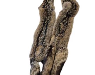 1302 - Fox Fur Scarf 42" (Description): A luxurious fox fur scarf featuring natural  brown and gray tones with darker striping  throughout. The scarf retains the natural  texture and coloring of the fox fur, with  plush, full pelts and intact tail ends that add elegant detail. The piece measures 42  inches in length, making it a versatile  accessory for draping around the neck or  shoulders.