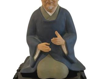 326 - Asian Man Figurine on Wood Stand 10" (Description): Figurine of a seated man on a carved wood  stand. Measures 10 inches.