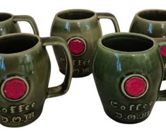 3966 - Set of 5 Green Ceramic Coffee D.O.M. Mugs (Description): Set of five green glazed ceramic coffee mugs  featuring a distinctive barrel-shaped design.  Each mug displays "Coffee D.O.M." lettering  and a red circular medallion on the front.  The mugs have sturdy handles and a rich green glossy finish characteristic of mid-century  barware styling.