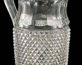 140 - American Brilliant Cut Glass Pitcher Vase 9" (Description): American Brilliant cut glass pitcher vase  featuring intricate diamond point cutting on  the lower body with a smooth upper section  and elegant curved handle. Measures 9 inches  in height.