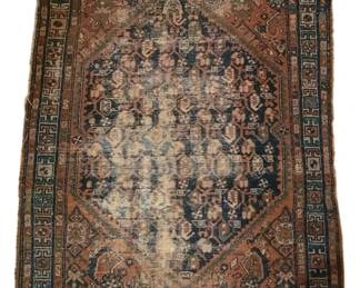 3769 - Worn Oriental Kazak Rug 41"x56" (Description): A worn antique Oriental Kazak rug featuring a  traditional geometric medallion design. The  rug displays a central diamond-shaped  medallion on a deep blue field, surrounded by  rust and coral corner spandrels with intricate geometric and floral motifs. The  border features a Greek key pattern in teal  and navy tones. The piece shows significant  wear throughout the center field, with  visible fading and distress consistent with