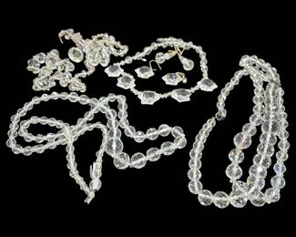 2702 - Group of Clear Faceted Glass Bead Jewelry (Description): A group of clear glass costume jewelry  featuring faceted crystal-style beads. The  collection includes multiple graduated bead  necklaces, a pair of drop earrings, and  additional beaded pieces. The beads display brilliant light refraction characteristic of  quality glass jewelry.