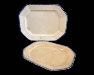 544 - 2 Ironstone Platters w/ Blue Feather Edge (Description): Pair of antique ironstone platters featuring  blue feather edge decoration. These octagonal  platters display the classic creamware body  with hand-painted blue shell edge borders  typical of early 19th century English pottery. Both platters show age-appropriate  wear including chips and staining consistent  with their age and use. Measures  17.5"x13"x5".