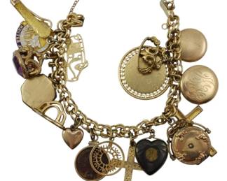 1772 - Mixed Gold Charm Bracelet Solid GF & Plated (Description): Mixed gold charm bracelet featuring a  collection of charms in solid gold, gold  filled, and gold plated finishes. The  bracelet showcases an assortment of  decorative charms including hearts, crosses, lockets, and various ornamental pieces. Total  weight 2.80 oz.