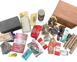 1209 - Vtg Tobacco Collection Pipes Cigars & Tins (Description): Vintage tobacco collection measuring  12"x8"x7". This assortment includes a wooden  cigar box, several tobacco pipes with wooden  bowls, loose cigars in tubes, various tobacco  pouches including Prince Albert, Stud, and Half and Half brands, cigarette packs from  Philip Morris, Winston, Salem, and Marlboro,  a tobacco tin, cigarette rolling papers  including Bugler, a black metal tobacco  cutter or dispenser, and assorted smoking